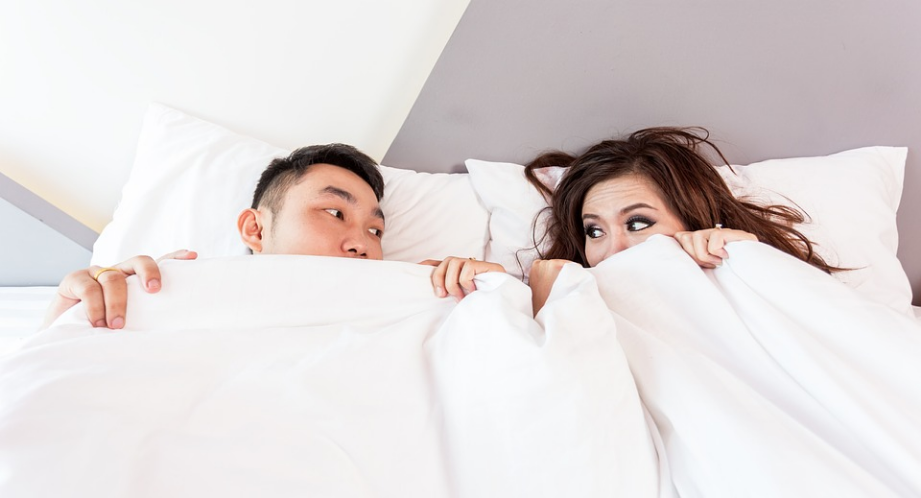 a couple cuddling in bed